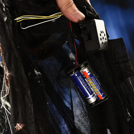Close-up of a device with batteries attached, held by a person against a dark background.