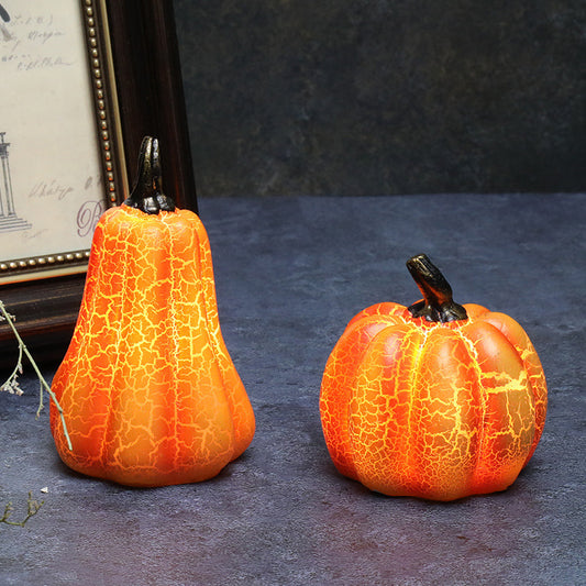 Two decorative pumpkins with a cracked texture on a dark surface.