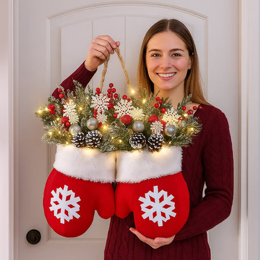 Person holding a decorative Christmas item shaped like red mittens with white snowflakes.