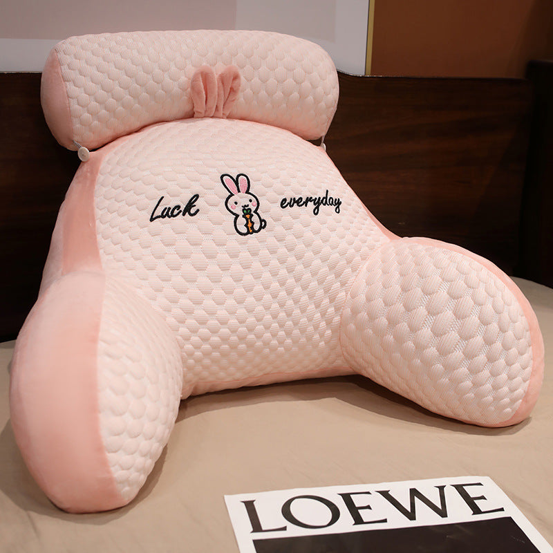 Pink backrest pillow with cartoon character and text on a surface