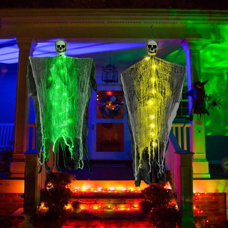 Halloween decorations with ghostly figures on a house porch.