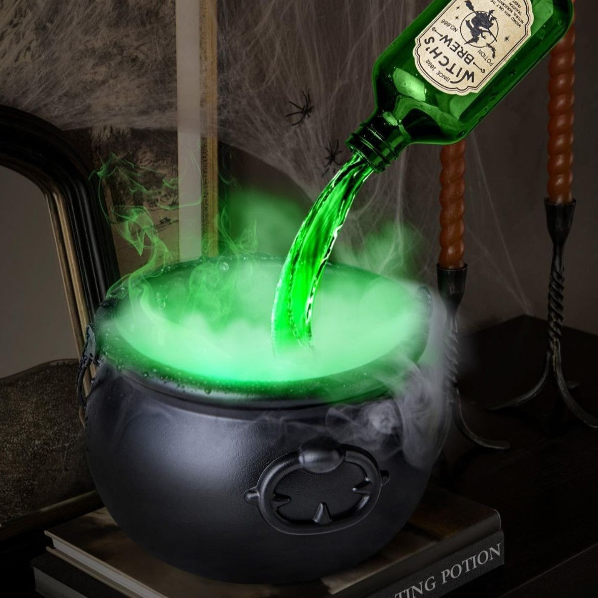 Green liquid being poured from a bottle into a black cauldron with smoke, on a dark background.