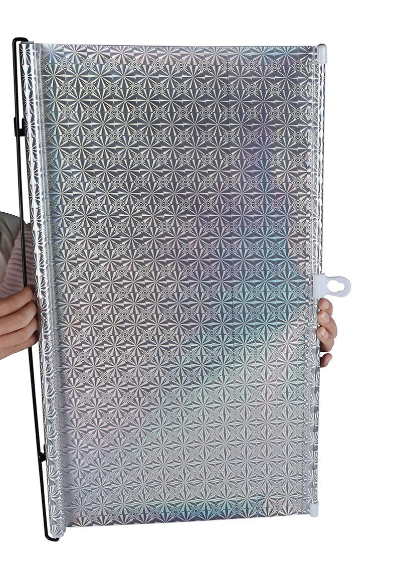 Metallic reflective panel with geometric pattern held by a person on a white background