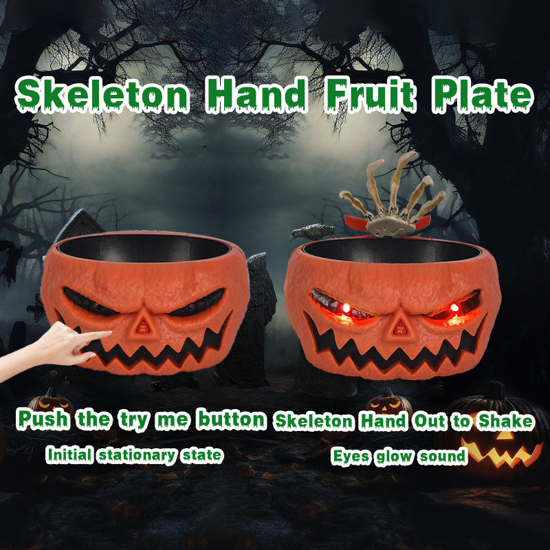 Halloween-themed fruit plate with skeleton hand design against a dark background.