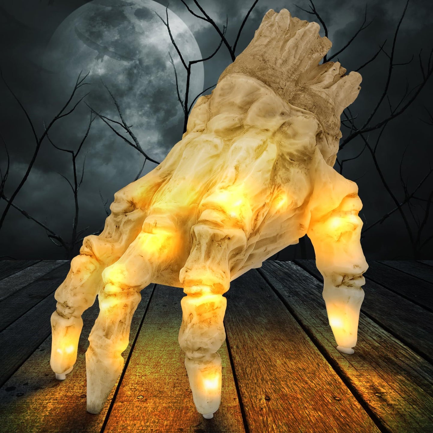 Decorative figure of a large spider with glowing eyes on a wooden platform against a dark, moonlit sky.