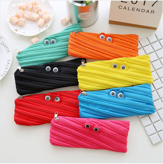Colorful pouches with cartoonish eyes on a white surface
