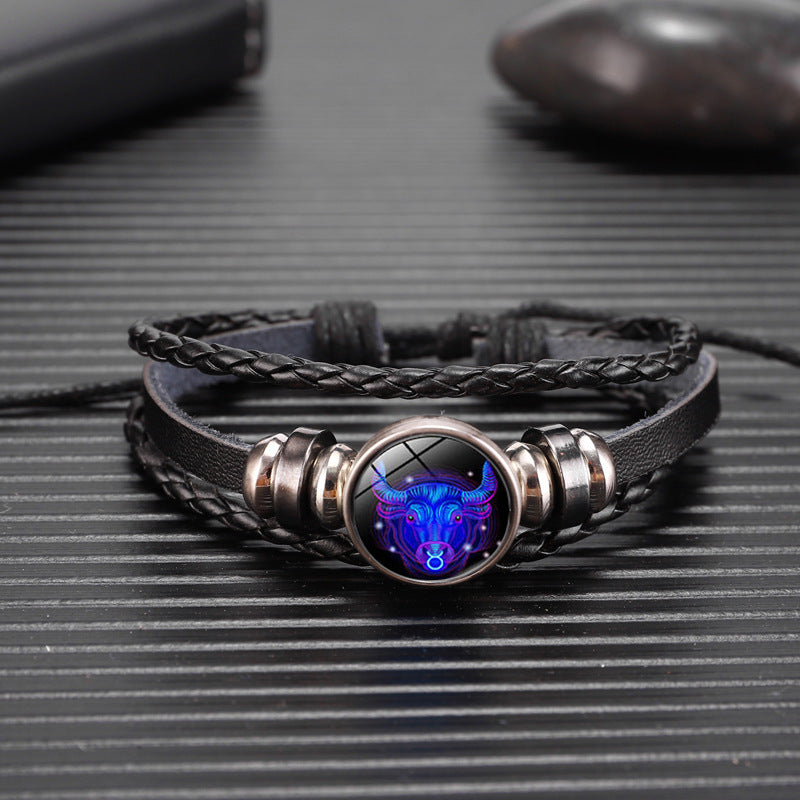 Bracelet with a dark leather strap and metallic clasp featuring a blue and purple wolf design on a textured surface.