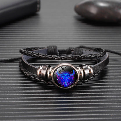 Bracelet with a dark leather strap and metallic clasp featuring a blue and purple wolf design on a textured surface.