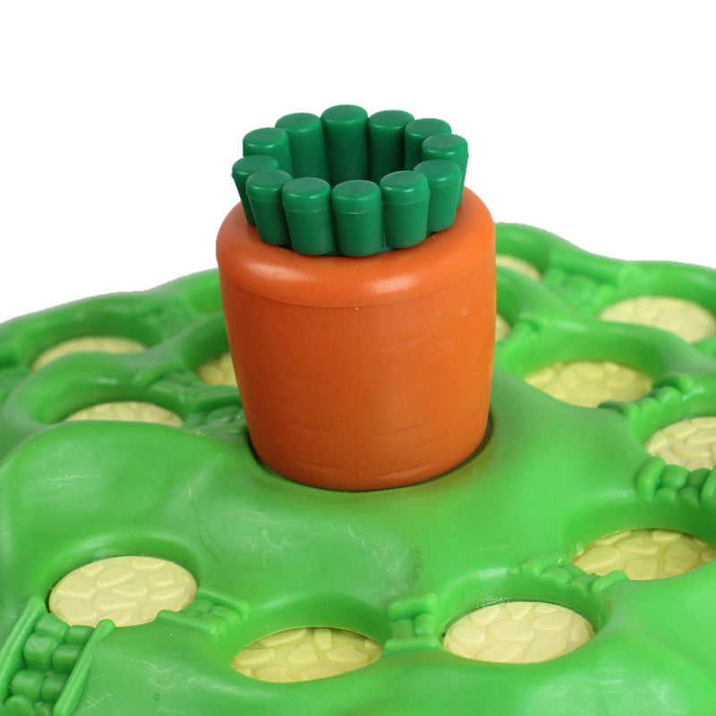 Toy carrot with green top on a green base with holes