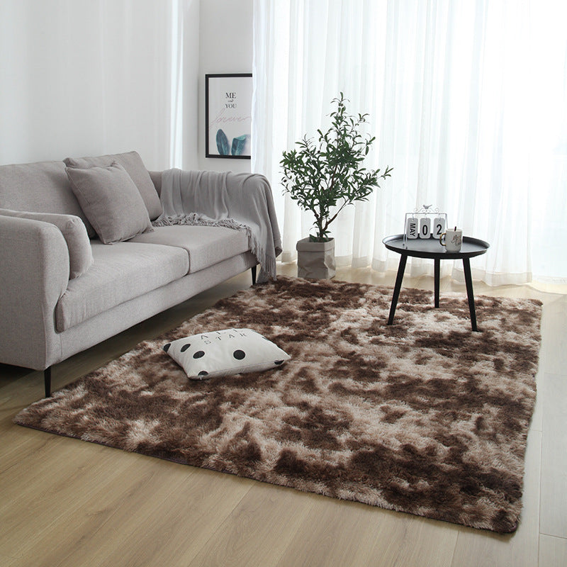 Living room with a brown rug, gray sofa, and small round table.