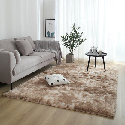 Living room with a brown rug, gray sofa, and decorative items.