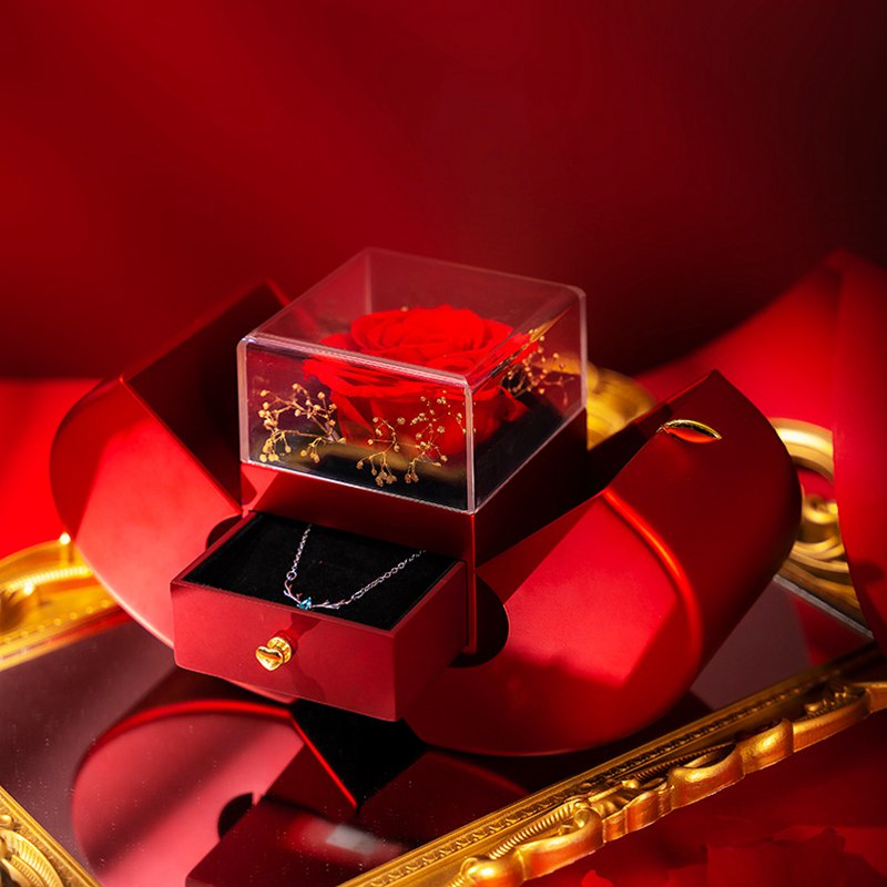 Red rose in a transparent box with a necklace inside, on a red background