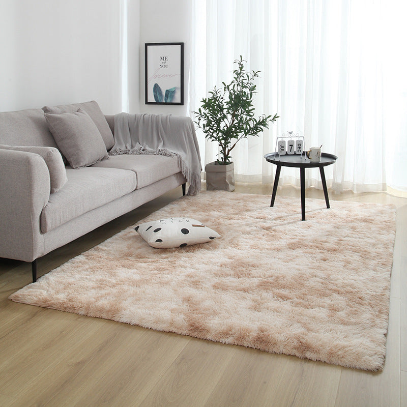 Living room with a beige rug, gray sofa, and a small round table.
