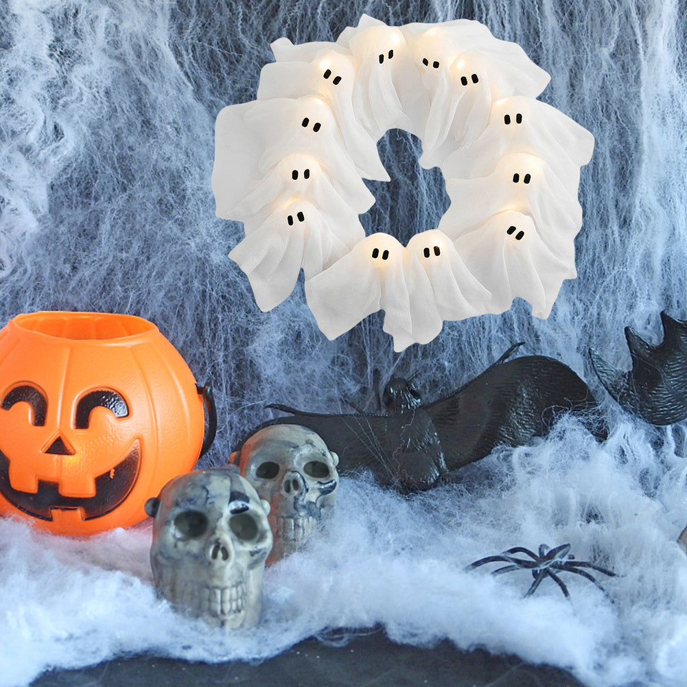 Halloween-themed decor with ghost wreath, jack-o'-lantern, skulls, and spider web.