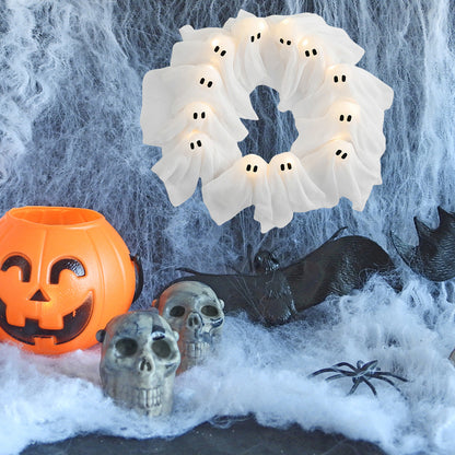 Halloween-themed decor with ghost wreath, jack-o'-lantern, skulls, and spider web.