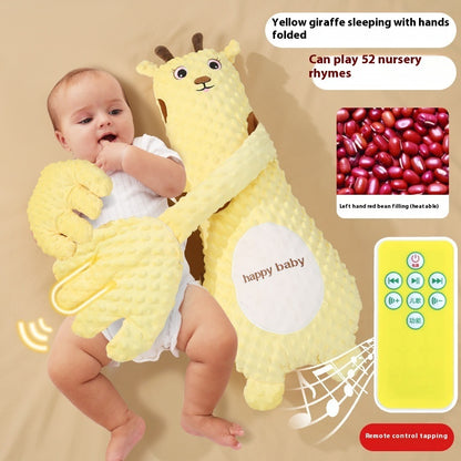Baby holding a yellow giraffe plush toy with remote control, sitting on a beige surface.