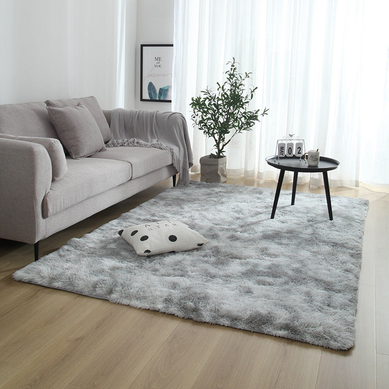 Living room with a gray rug, sofa, and small table.