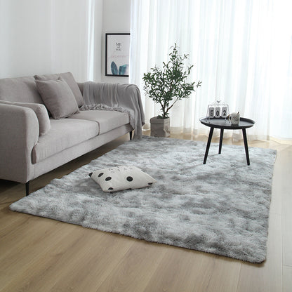 Living room with a gray rug, sofa, and small table.