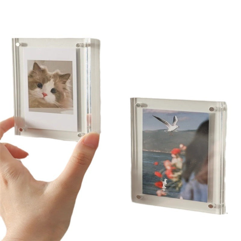 Clear photo frames held by a hand with images of a cat and a beach scene.