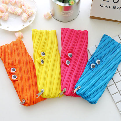 Four colorful pouches with googly eyes on a white surface