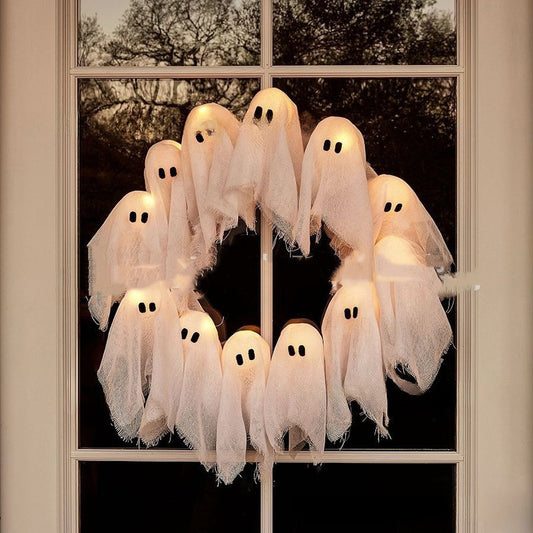 Halloween ghost decorations hanging in front of a window
